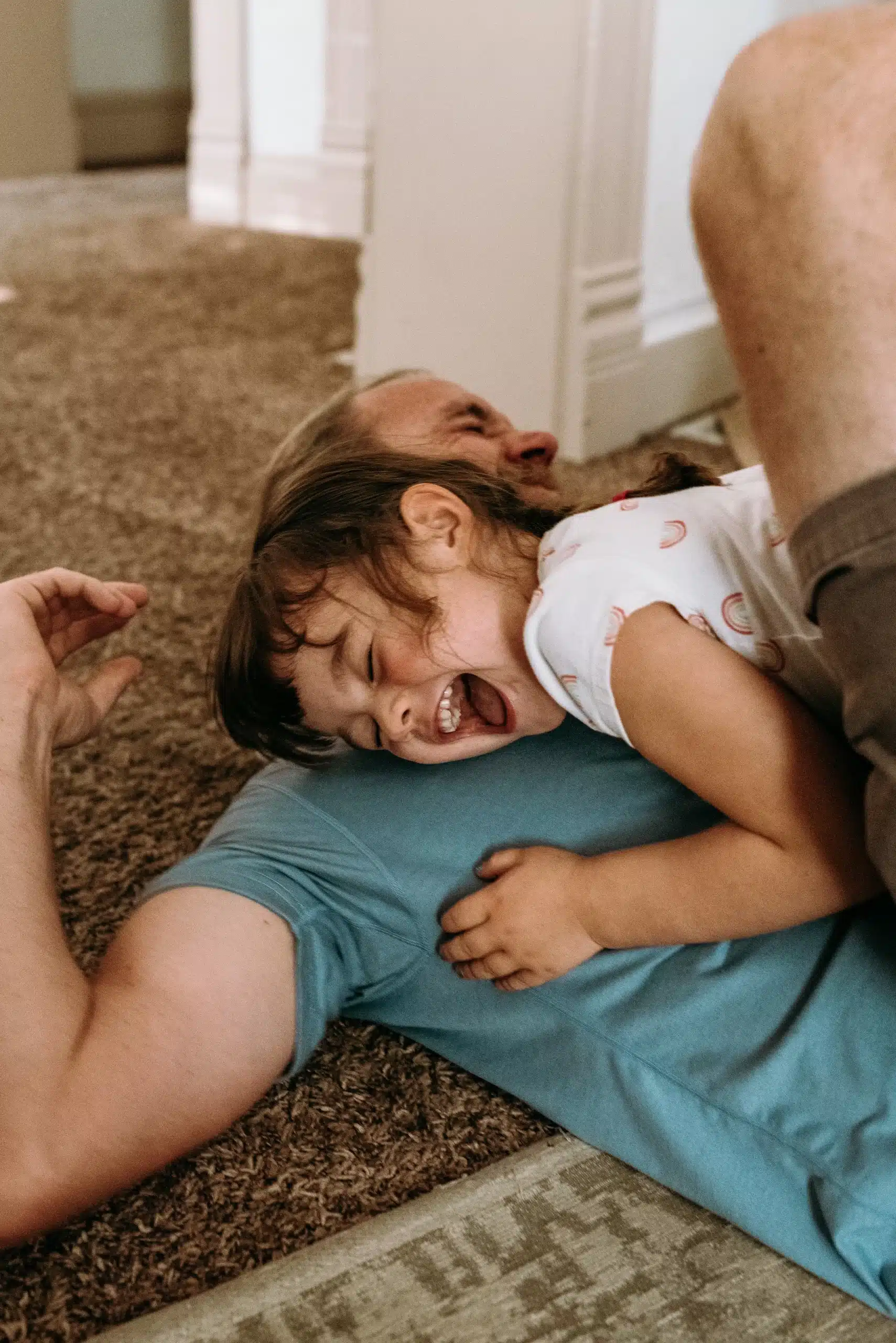 Father and daughter laughing while playing.