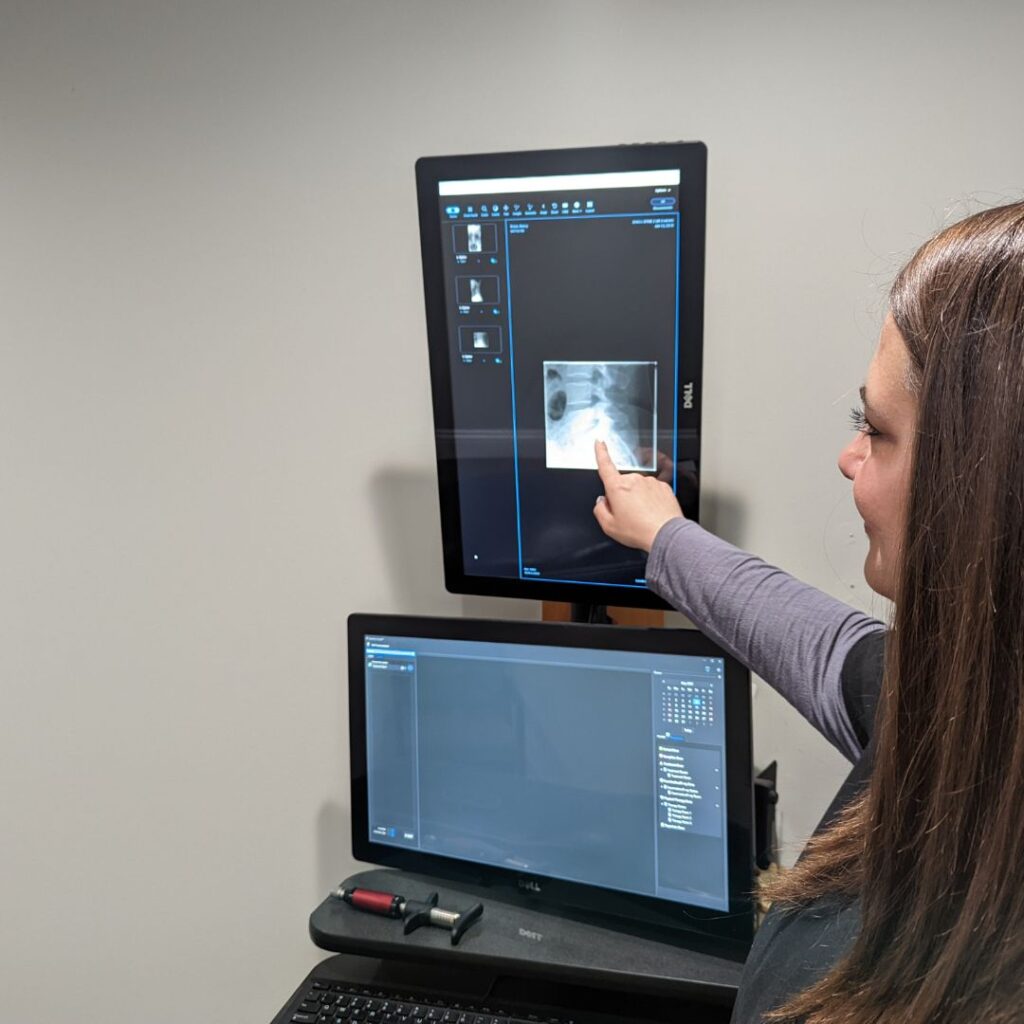 Dr. Faith shows a patient an x-ray in the office at Simply Well Chiropractic.